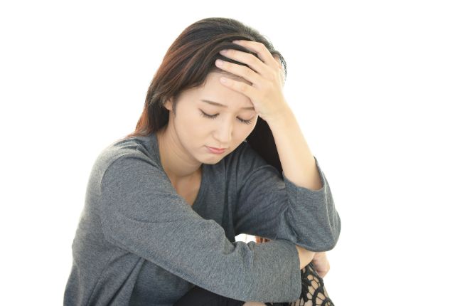 額をおさえる女性